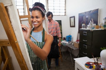 Man and woman painting on canvas