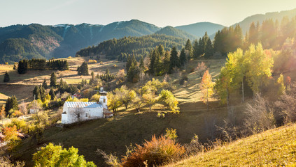 Autumn landscape with church located in village Gela, in the hearth of Rodopi Mountain, Bulgaria. Panoramic view with flairs