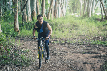 Cyclist riding mountain bike on rocky trail at sunrise.