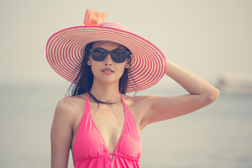 Portrait of Beautiful Asian Woman standing at the Beach, People with Summer Concept,  Woman with Happy Emotion on Vocation. Vintage tone.