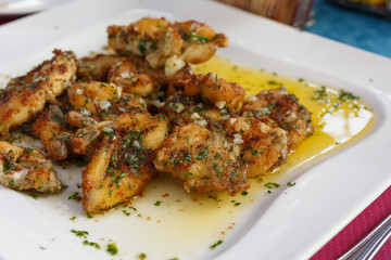 French traditional dish frog paws with parsley and garlic top view. gastronomic dish of French cuisine