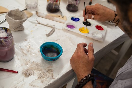 Man mixing watercolor in palette - Powered by Adobe
