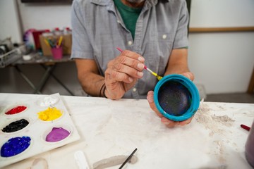 Mid section of man painting bowl