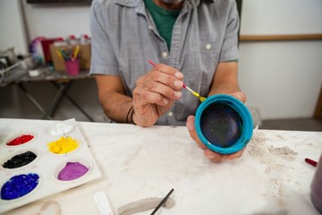 Mid section of man painting bowl - Powered by Adobe