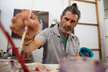 Attentive man painting bowl