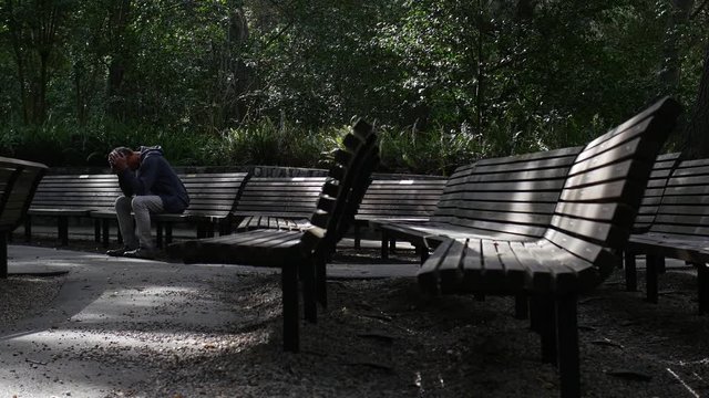 UNHAPPY MAN SITS ALONE IN THE PARK, 4K.  Model release.