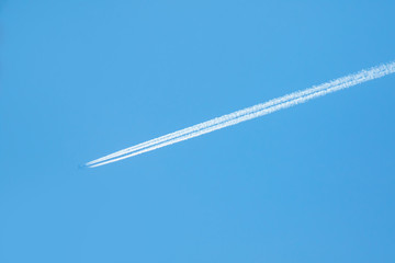 trail of white smoke from the airplane on blue sky