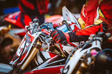 Close-up view on hands on handlebars. Biker sitting on motorcycle in starting point