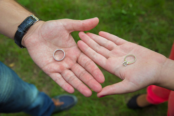 The girl and the boy hold the ring in your hands. On the green background. love story