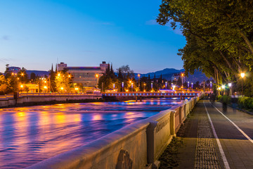 Night view of illuminated Kubanskiy bridge and embankment of Sochi river, Sochi, Russia
