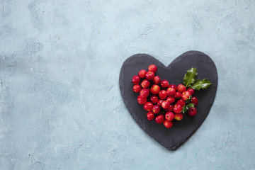 Symbol of a heart with a Christmas decor on a light background. Top view, background