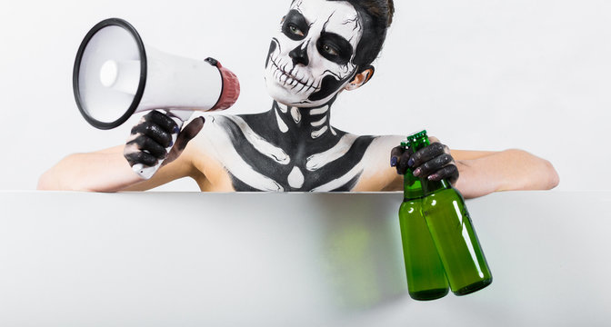 Attractive girl with skeleton makeup hold bottle and megaphone