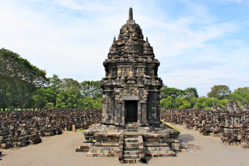 Obraz premium Sewu Temple is the second largest Buddhist temple complex in Java; built in 8th century; blue sky with white clouds and green trees around the ruins