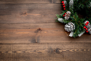 Christmas wreath woven of spruce branches with red berries on wooden background top view copyspace