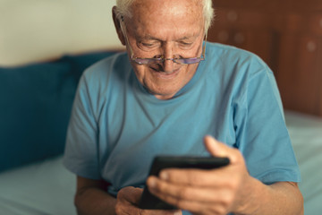 Senior man using digital tablet. Surprised mature male using portable computer at home