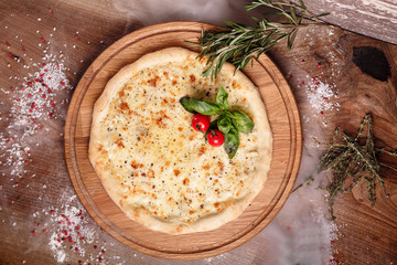 Thick delicious cheese pizza vegetarian dish with cherry tomato and herbs