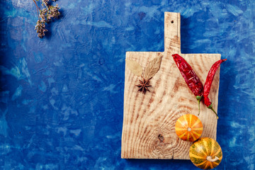 on a kitchen board pepper and pumpkin on a blue background concrete