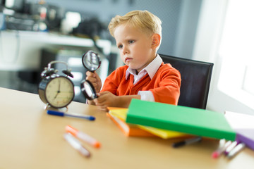 Young boy sit at the desk in the office