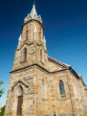Fototapeta na wymiar Grand Gothic Revival Catholic Church Against Blue Sky
