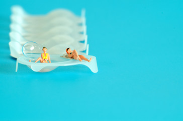 Miniatures of women taking sunbathing in a eye contacts holder box. Background for healthcare and...