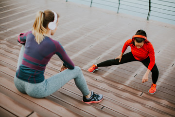 Young woman exercising with a personal trainer outside