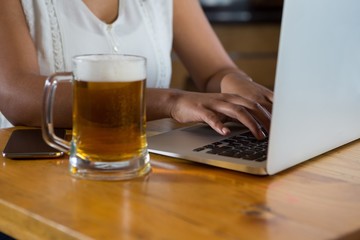 Woman using laptop at bar