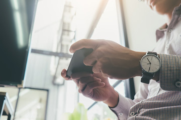 Business process photo. Account manager using mobile phone. Typing contemporary smartphone screen.