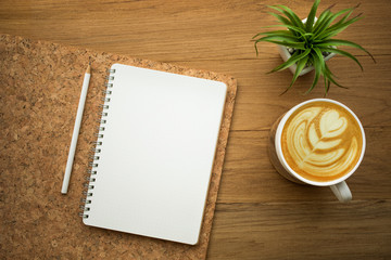 Blank white notepad with coffee latte on wood table.Business flat lay background