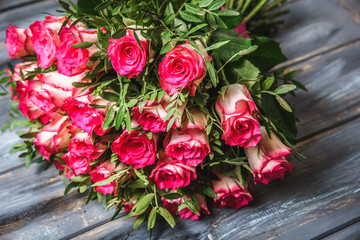 Pink roses bouquet over wooden table. Top view with copy space