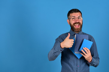 Guy with happy face and books shows thumbs up