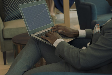 Business man holding his laptop and looking into chart