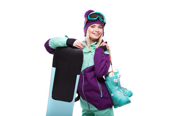 young attractive woman in purple ski suit hold snow boots and snowboard