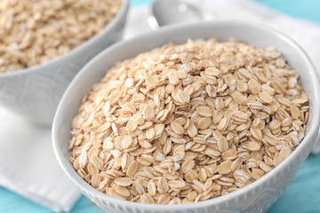 Bowl with raw oatmeal on table, closeup