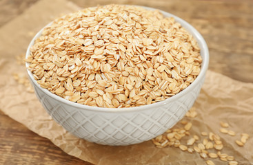 Bowl with raw oatmeal on table