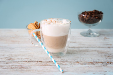 Glass cup with latte macchiato on wooden table