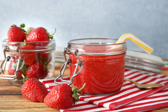 Glass jar with strawberry smoothie on striped fabric