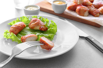 Fork with bacon wrapped chicken on plate