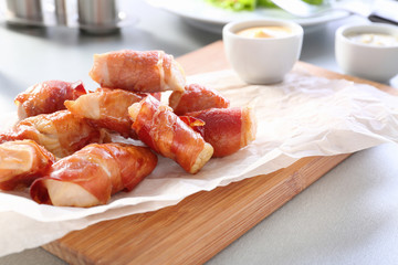 Bacon wrapped chicken on wooden board