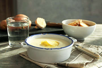 Tureen with potato cream soup on table