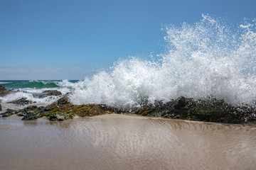 Crashing Wave Against Rock on Beach