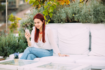 Young woman at cafe using mobile phone   