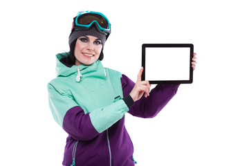 young pretty woman in purple ski costume and ski glasses hold empty tablet