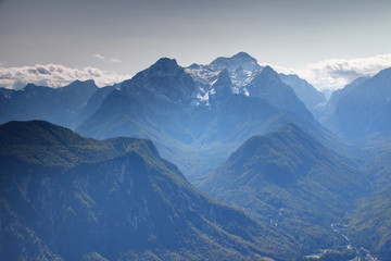 Snowy Triglav and Rjavina peaks from the north with forested Jerebikovec peak and deep Vrata, Kot and Sava Valley in a sunny autumn day, Triglav National Park, Julian Alps, Slovenia, Europe © nogreenabove2k