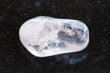 polished clear quartz gemstone on dark background