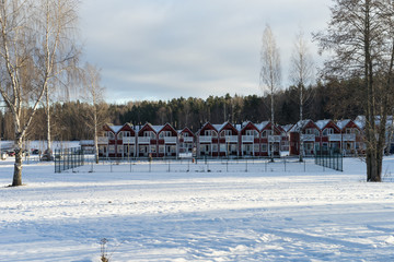 Fototapeta premium Cute townhouses near the river during sunny winter day. Imatra, Finland - January 20, 2017