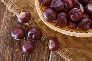 Chestnuts in wooden bowl  on an old rustic table