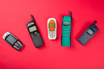 Old mobile phones on red background
