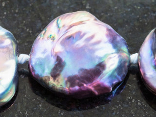 bead from Haliotis gemstone on dark background
