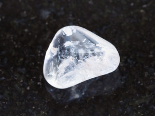 tumbled rock crystal gemstone on dark background