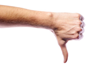 The man gestures his disapproval. The thumb is pointing down. The young guy is indignant, refuses, he does not like. A male hand shows a symbol on a white background in a photo studio.